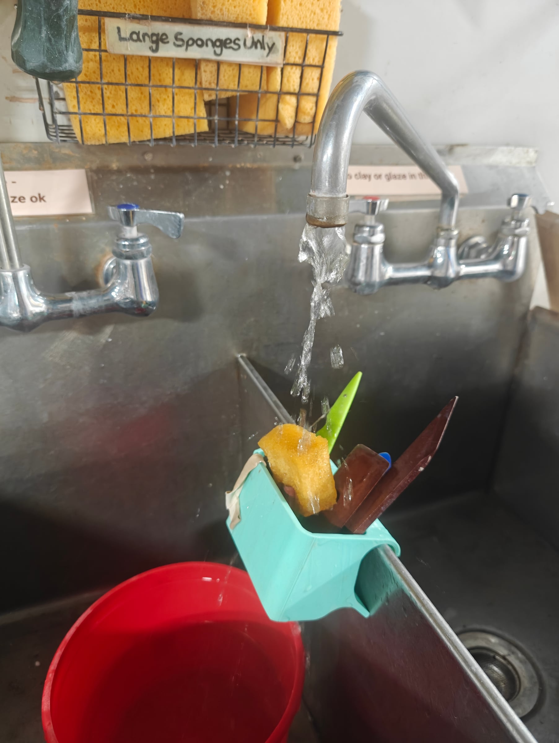 Tool caddy hooked on a sink edge while tools rinse