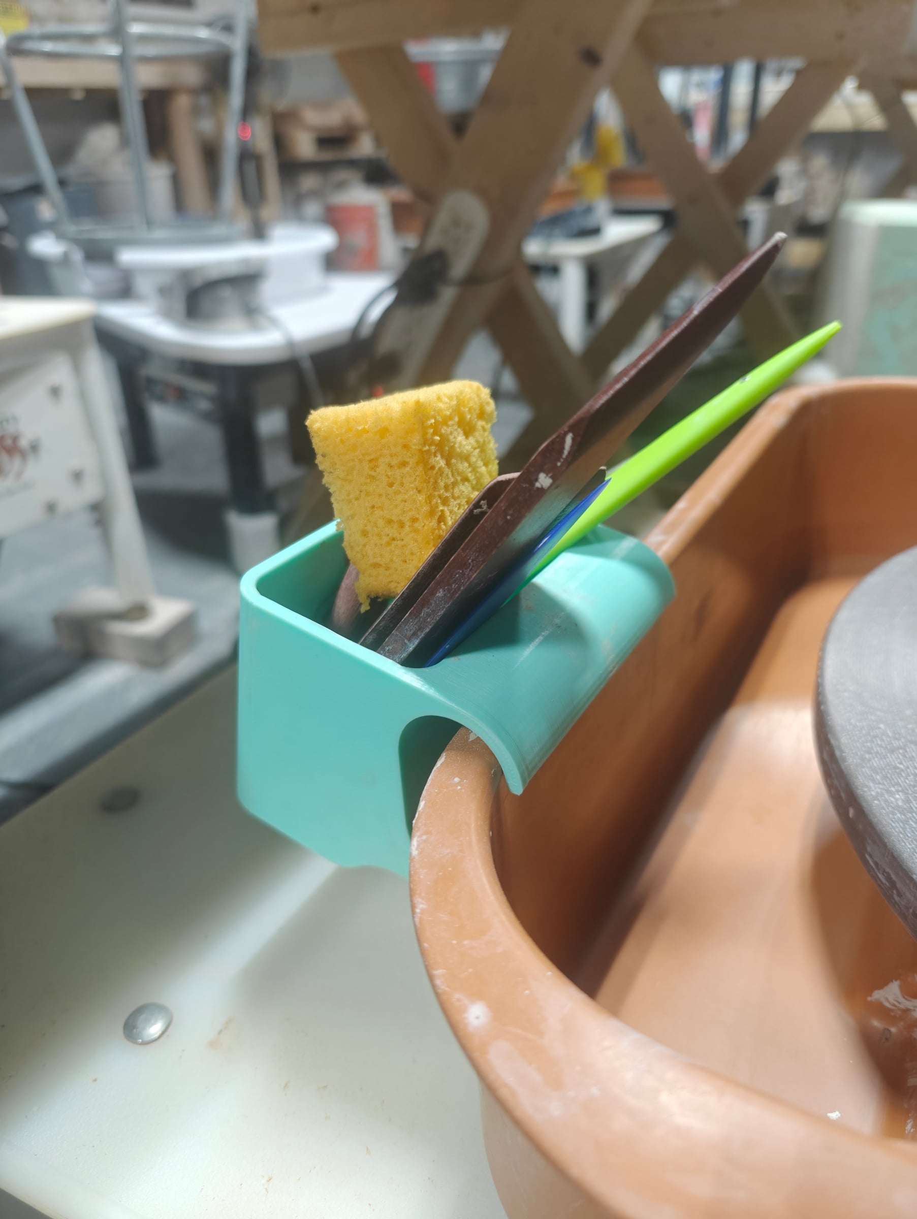 Tool caddy holding a sponge and ribs at the wheel